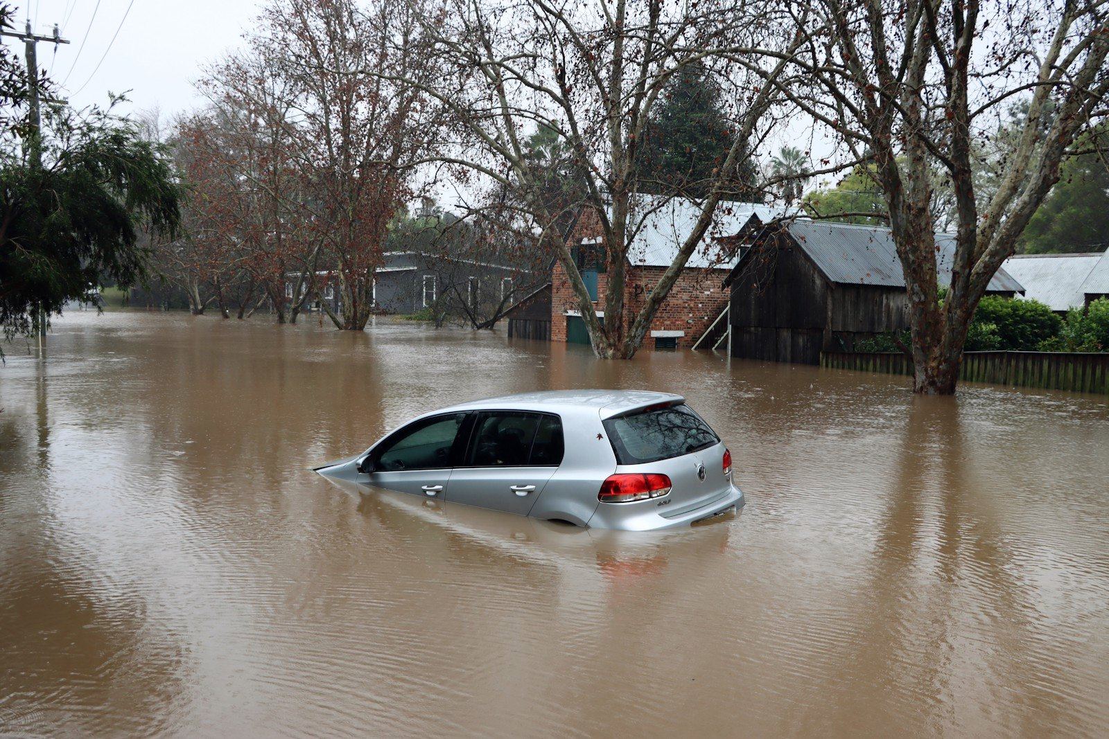 Coche medio hundido en una calle inundada
